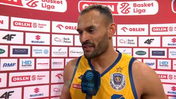 Mężczyzna w ż&oacute;łto-niebieskiej koszulce sportowej z logo "Basket Liga" udziela wywiadu, trzymając mikrofon.