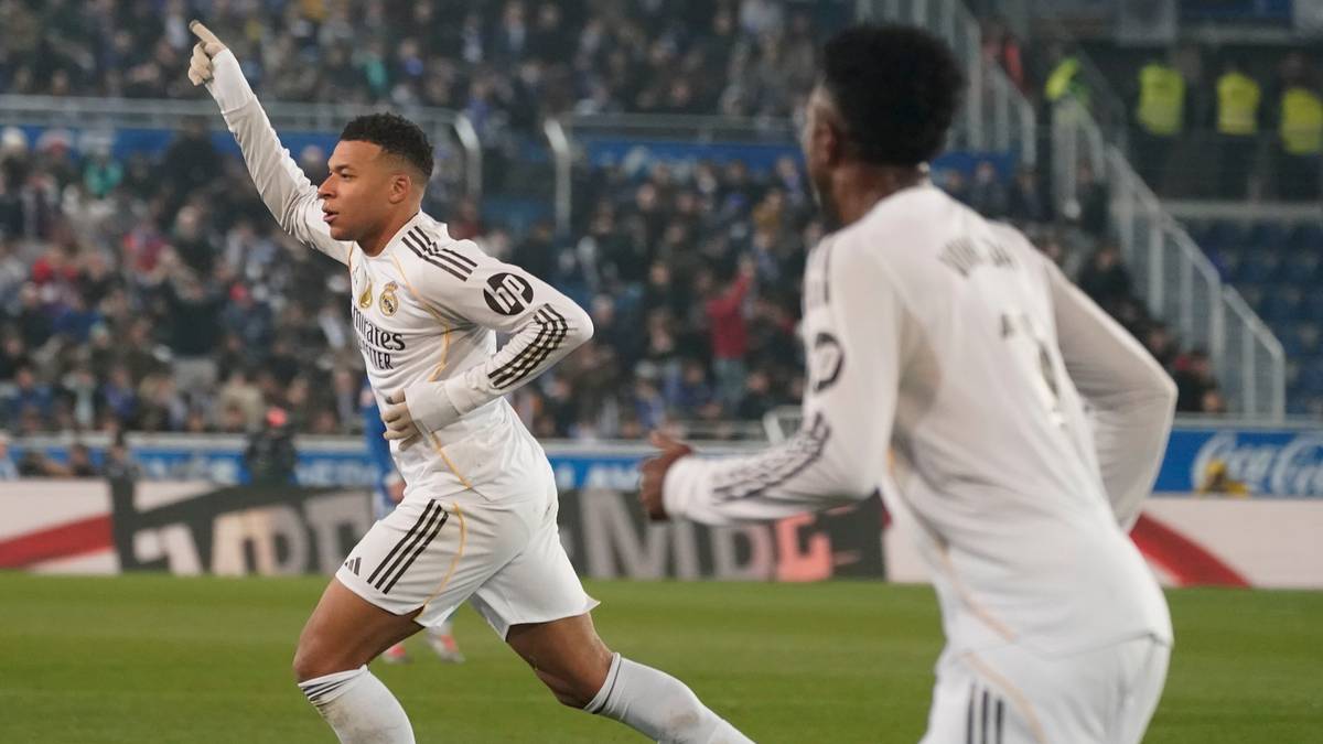 Dw&oacute;ch piłkarzy Realu Madryt w białych strojach świętuje bramkę na zielonym boisku.