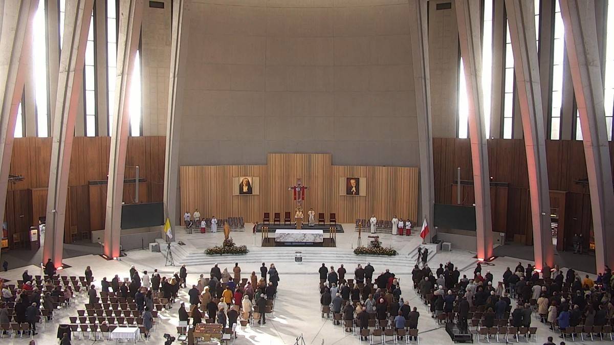 Widok na wnętrze kościoła z ołtarzem i wiernymi zgromadzonymi na nabożeństwie.