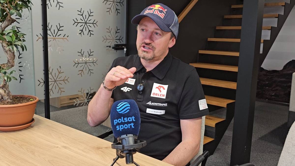 Mężczyzna w czapce z daszkiem i koszulce Polsat Sport udziela wywiadu.