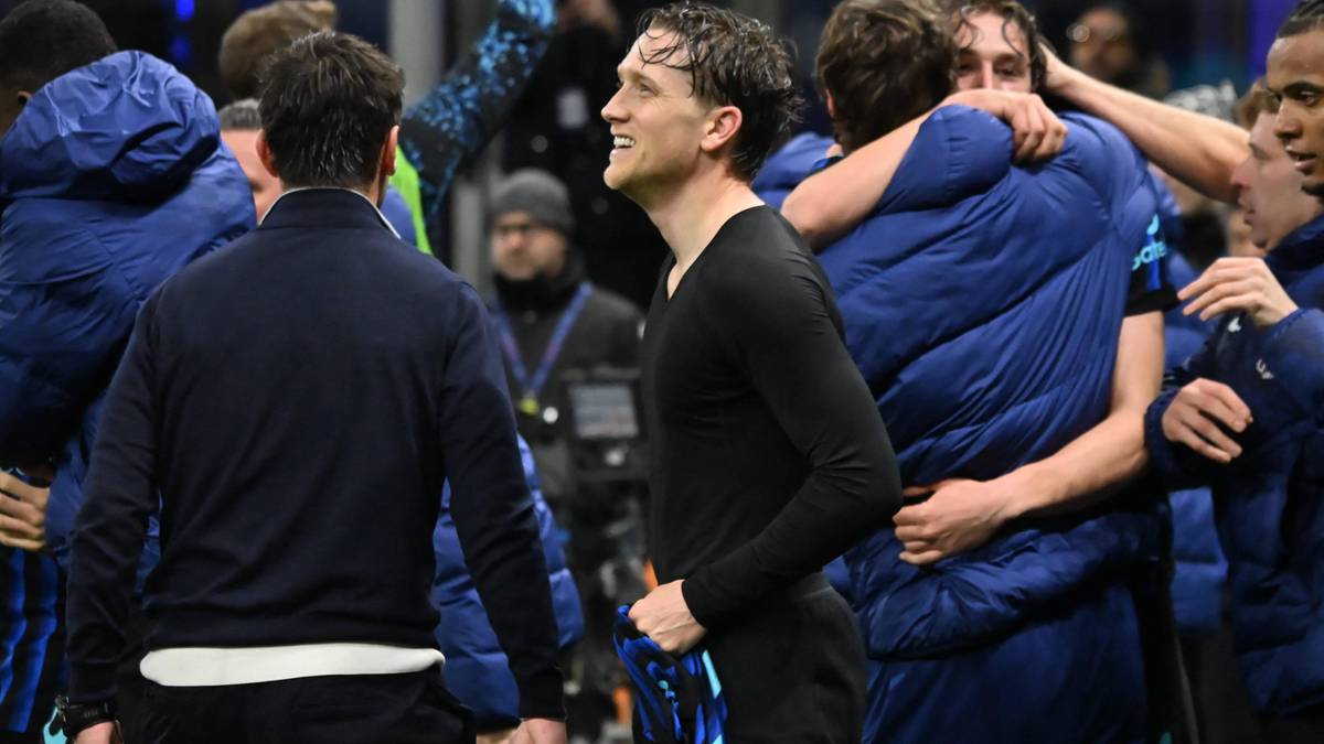 Piłkarze w niebieskich strojach cieszą się z sukcesu, jeden z nich uśmiecha się do widza.