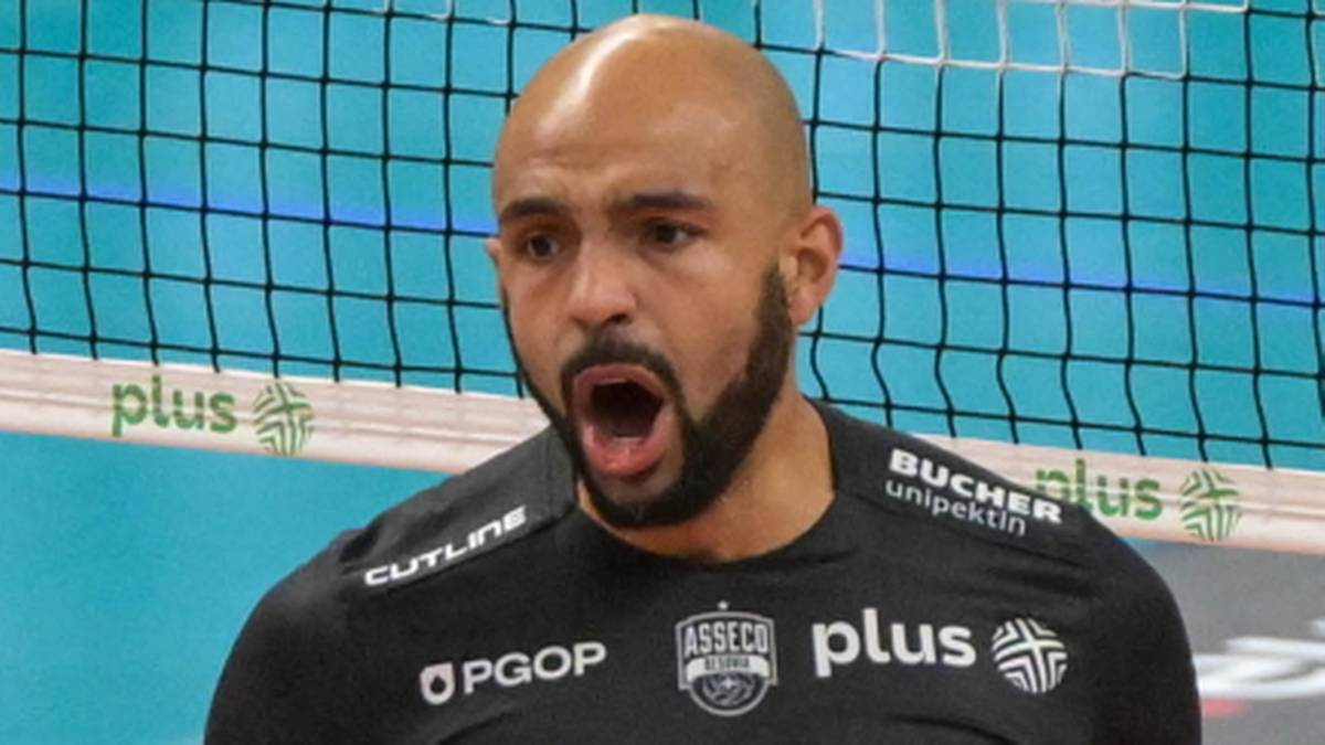 Siatkarz w czarnej koszulce z numerem 6 na plecach, z okrzykiem radości i zaciśniętymi pięściami.