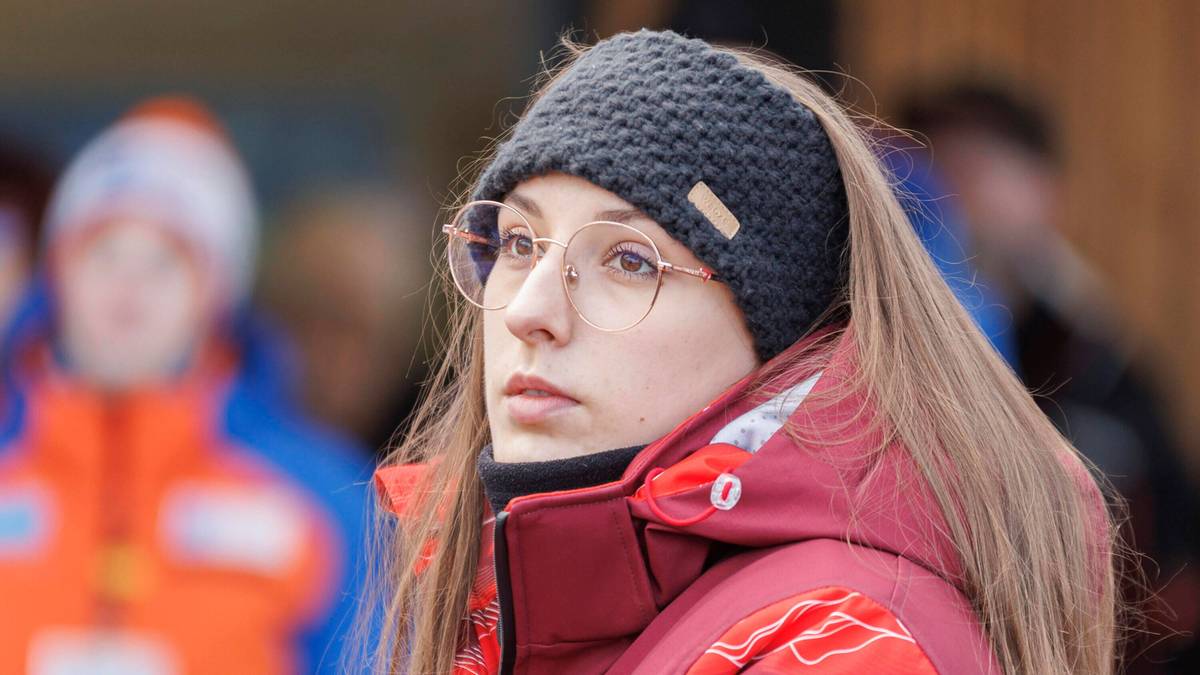 Kobieta w okularach i czapce na głowie, ubrana w kurtkę sportową.