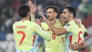 Piłkarze w żółtych koszulkach świętują zwycięstwo, przybijając sobie piątki.