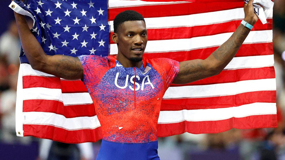 Fred Kerley, lekkoatleta, trzyma amerykańską flagę po zawodach.