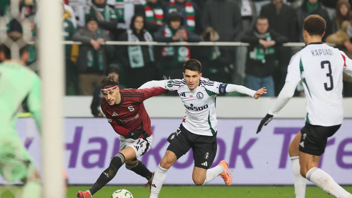 Piłkarze walczący o piłkę na boisku podczas meczu.