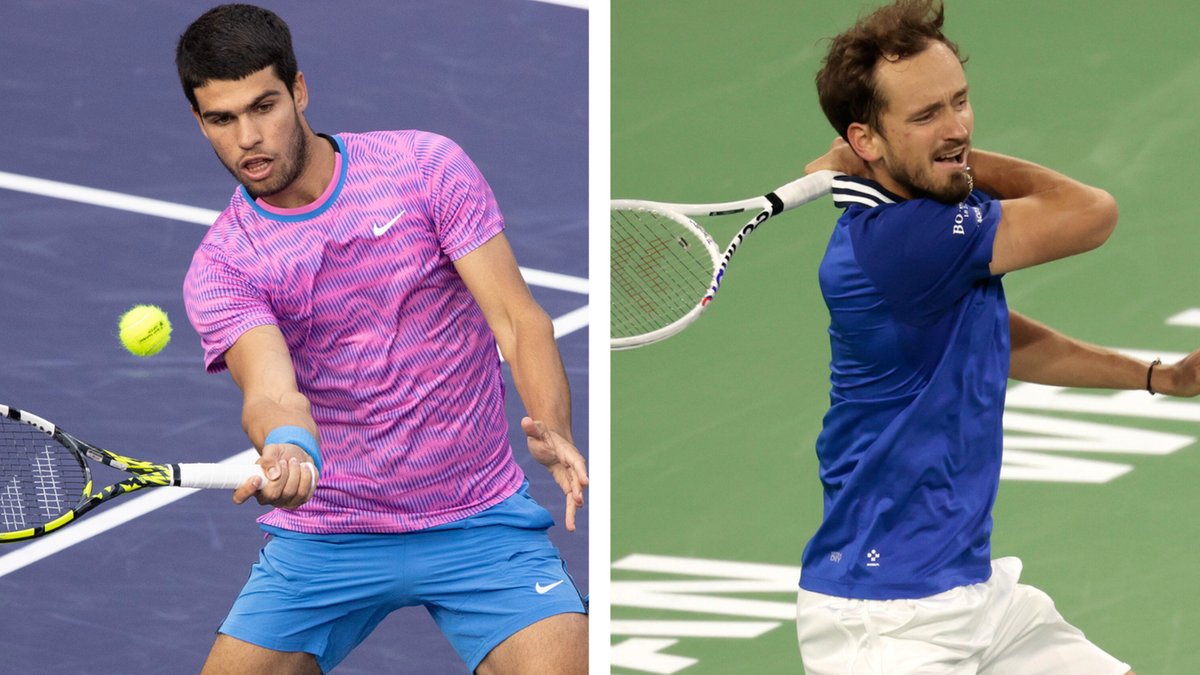 Dw&oacute;ch tenisist&oacute;w podczas meczu: Carlos Alcaraz w r&oacute;żowej koszulce z niebieskimi wzorami i Daniił Miedwiediew w niebieskiej koszulce.