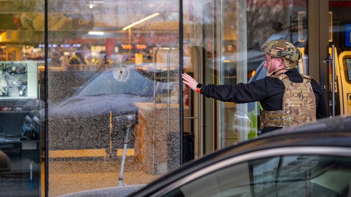Mężczyzna w kamizelce taktycznej wchodzi do budynku.