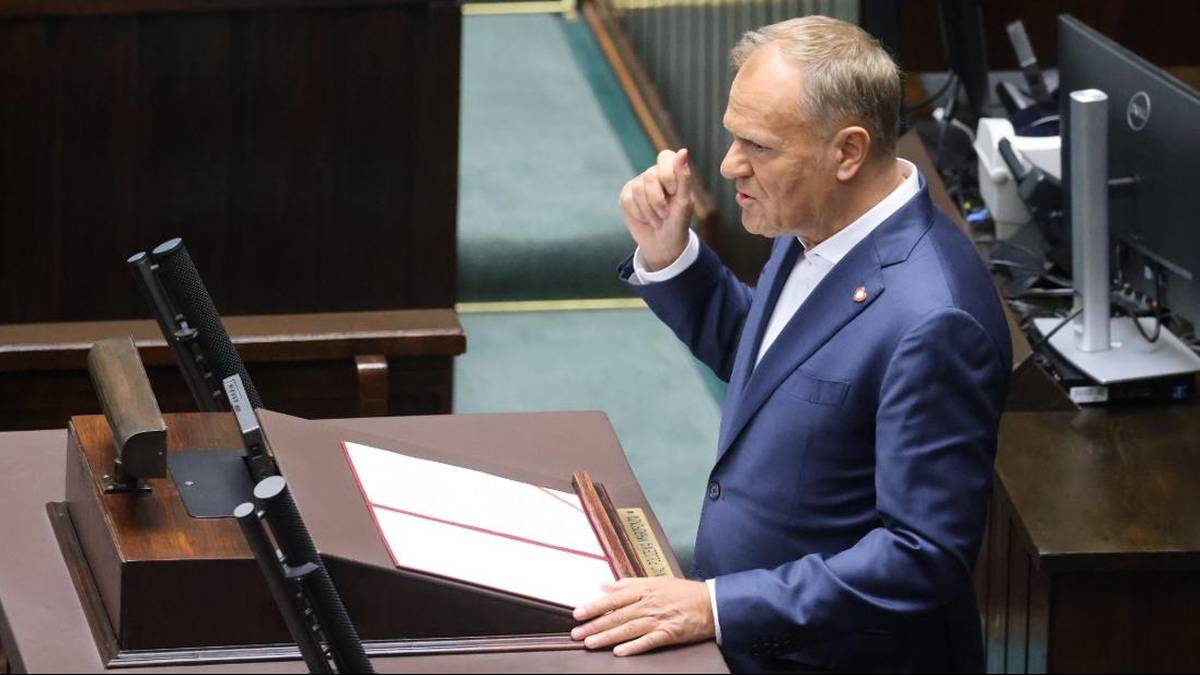 Premier Donald Tusk przemawia przy mównicy w sali sejmowej.
