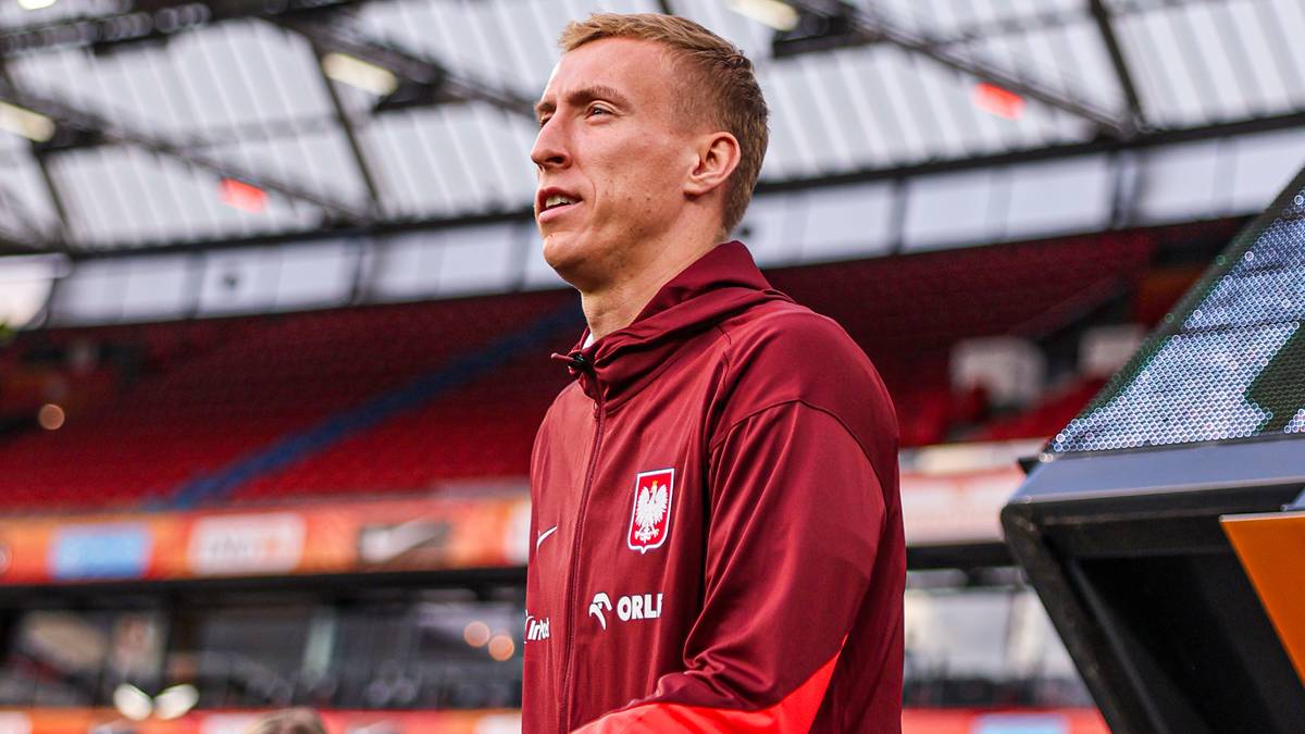 Piłkarz reprezentacji Polski w nowym stroju, patrzący w bok z determinacją.