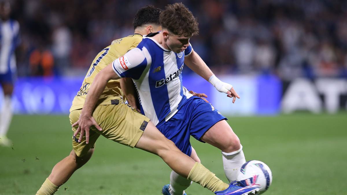 Dwóch piłkarzy FC Porto walczy o piłkę z zawodnikiem Famalicao na murawie boiska.