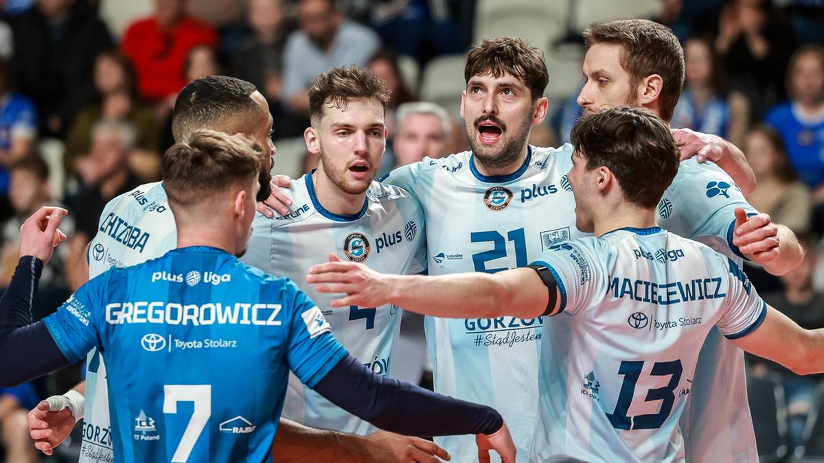 Siatkarze drużyny Cuprum Stilon Gorz&oacute;w cieszą się ze zwycięstwa po meczu, ściskając się i rozmawiając.