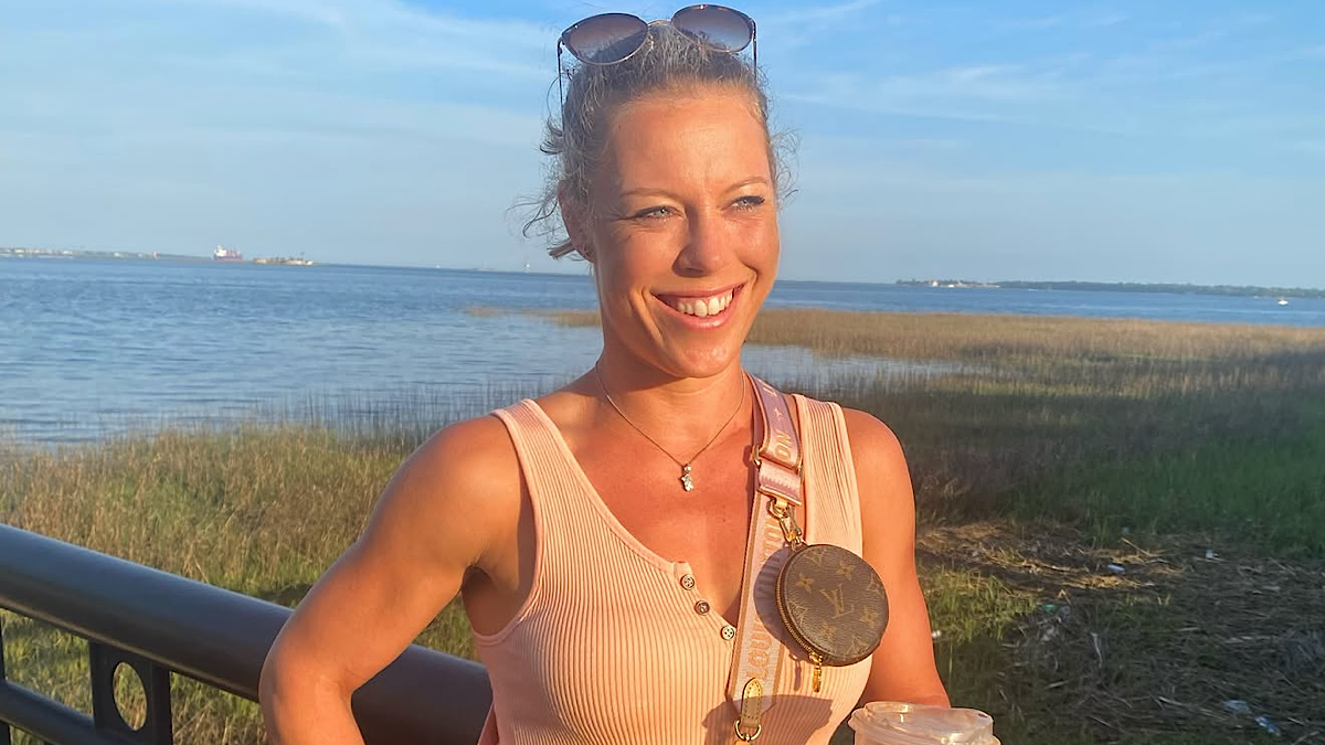 Uśmiechnięta kobieta, tenisistka Laura Siegemund, na tle nadmorskiego krajobrazu.