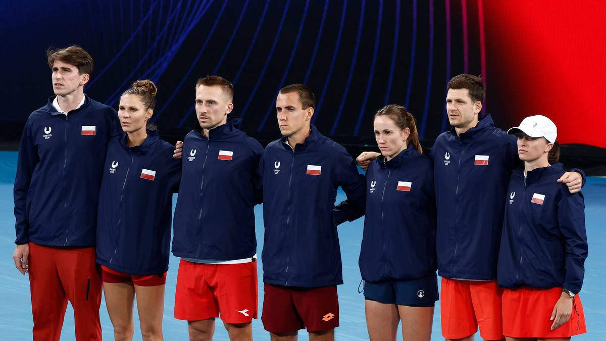 Siedmiu członk&oacute;w polskiej drużyny tenisowej w strojach reprezentacyjnych.