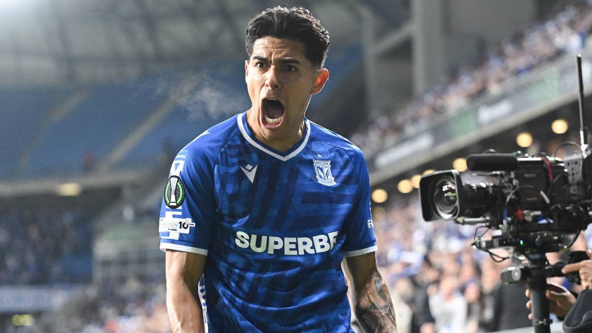 Piłkarz Lecha Poznań w niebieskiej koszulce celebruje strzelenie gola na stadionie.