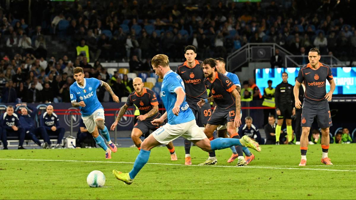 Piłkarze walczący o piłkę podczas meczu, jeden z nich oddaje strzał.