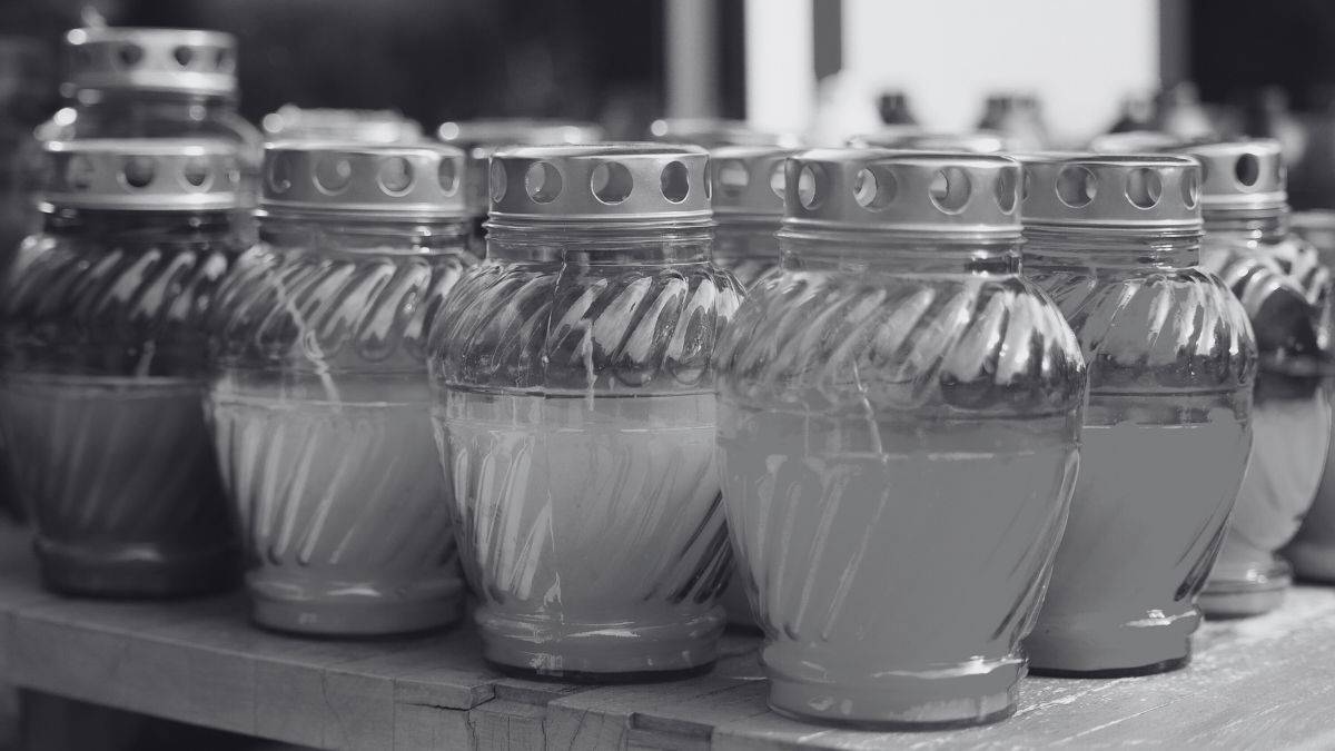 Grupa zniczy ustawionych w rzędzie na drewnianej powierzchni.