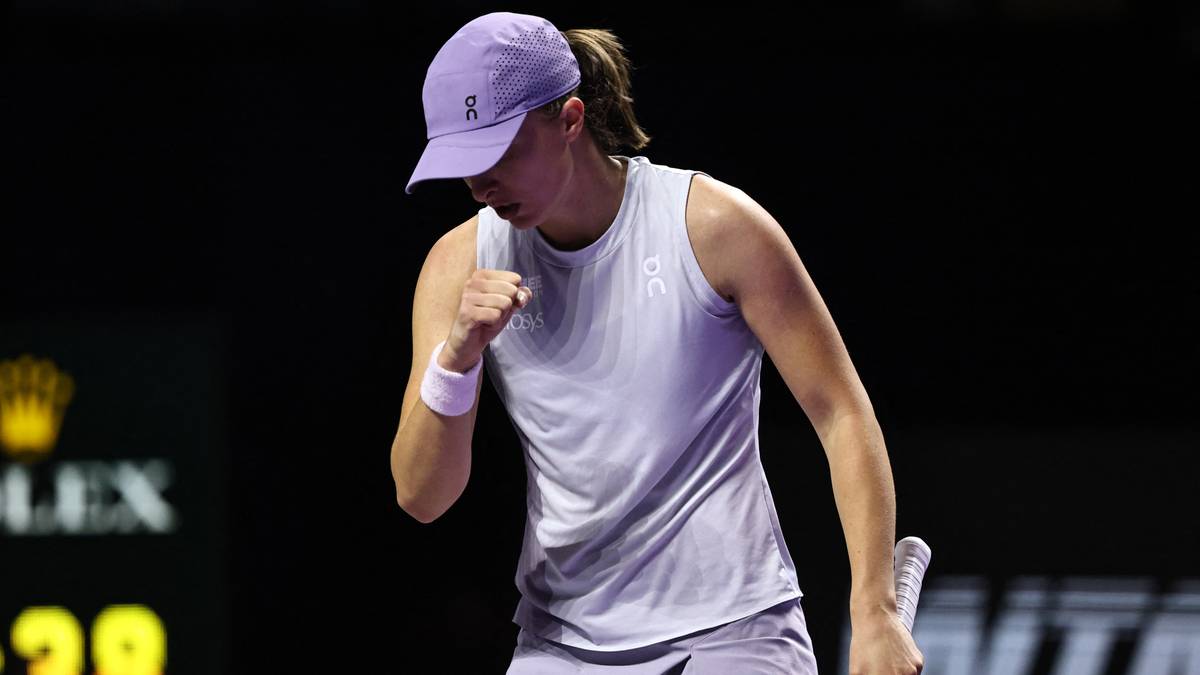 Iga Świątek, polska tenisistka, w biało-fioletowym stroju, zaciśniętą pięścią świętuje zwycięstwo na korcie tenisowym.