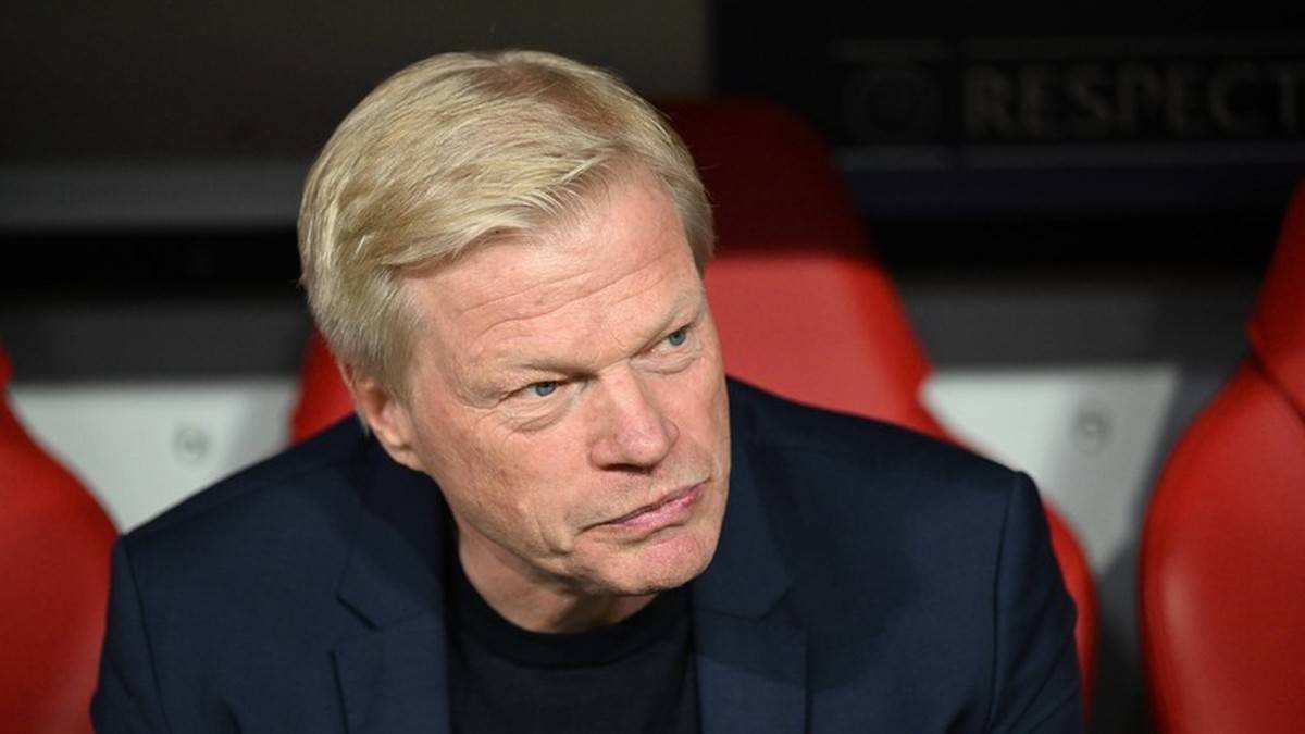 Portret poważnie wyglądającego mężczyzny z blond włosami, ubranego w granatową marynarkę.