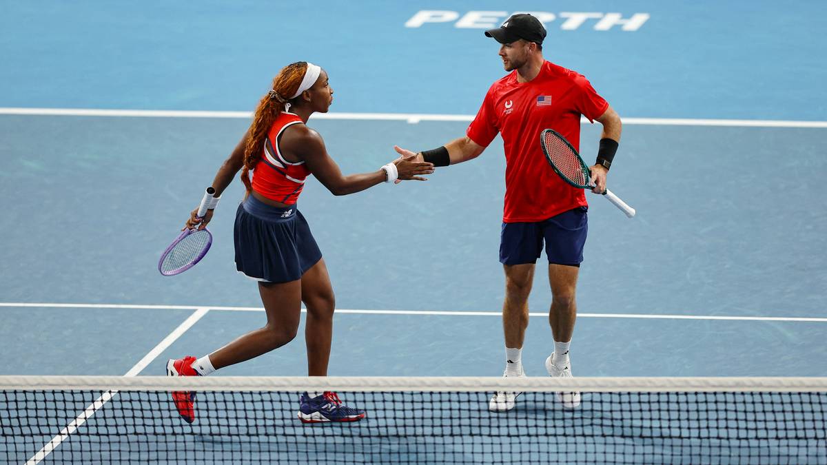Coco Gauff i Christian Harrison z USA podają sobie ręce przez siatkę po wygranym meczu.