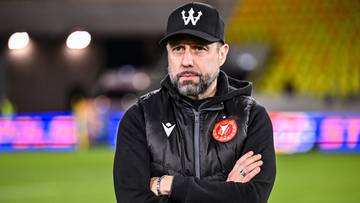 Mężczyzna w czapce i kamizelce na boisku piłkarskim