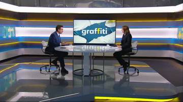 Dwóch ludzi siedzi przy okrągłym stole w studiu telewizyjnym. Na ekranie wyświetla się napis "graffiti".