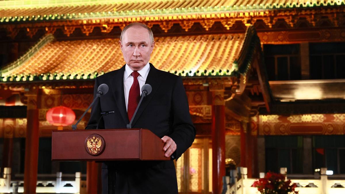 Władimir Putin stoi za mównicą.