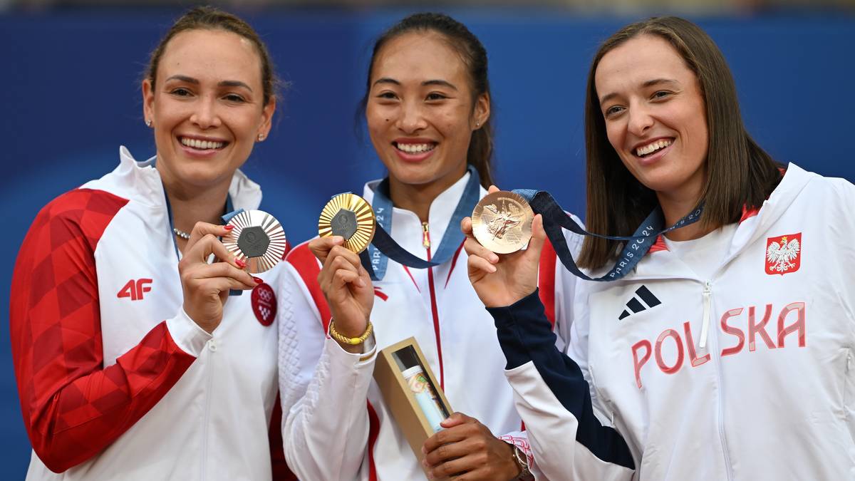 Trzy zawodniczki z medalami tenisowymi, w tym Polka w stroju z napisem "POLSKA"
