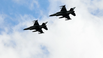 Dwa myśliwce F-16 w locie na tle nieba.