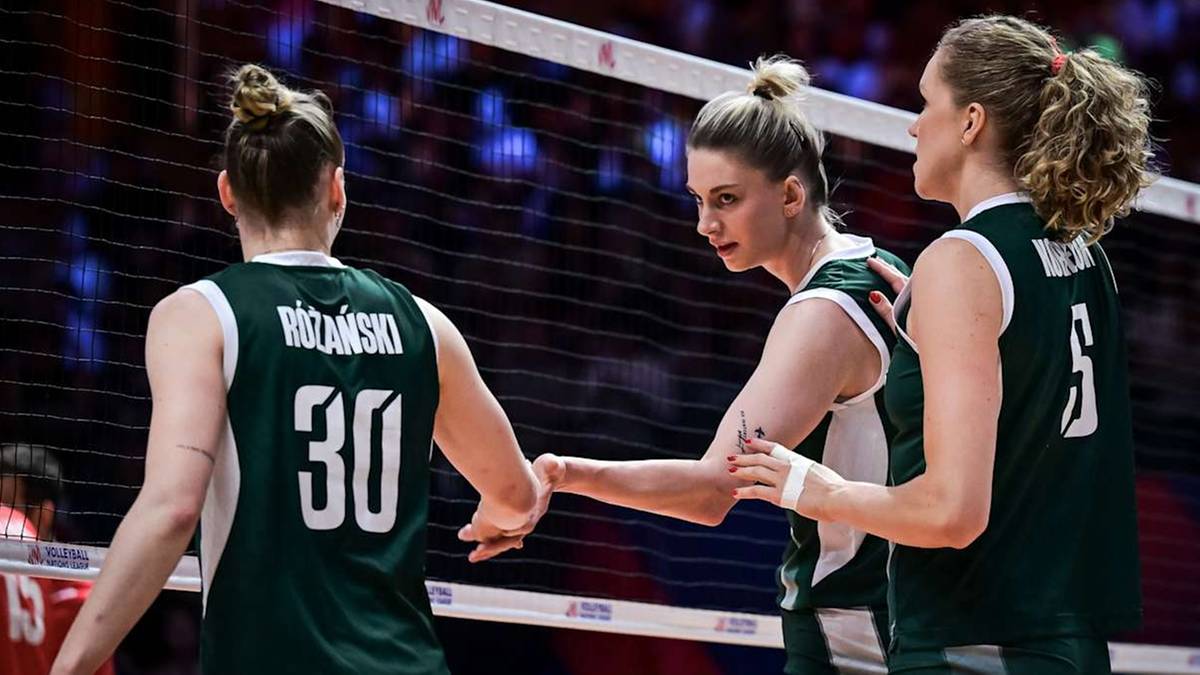 Trzy siatkarki w zielonych strojach stoją przy siatce po meczu. Jedna z nich ma numer 30 na plecach.