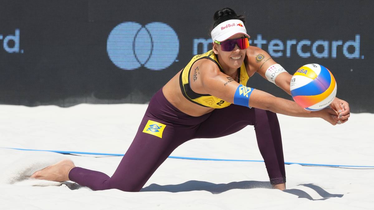 Siatkarka plażowa w pozycji obronnej, przyjmująca piłkę na piasku.