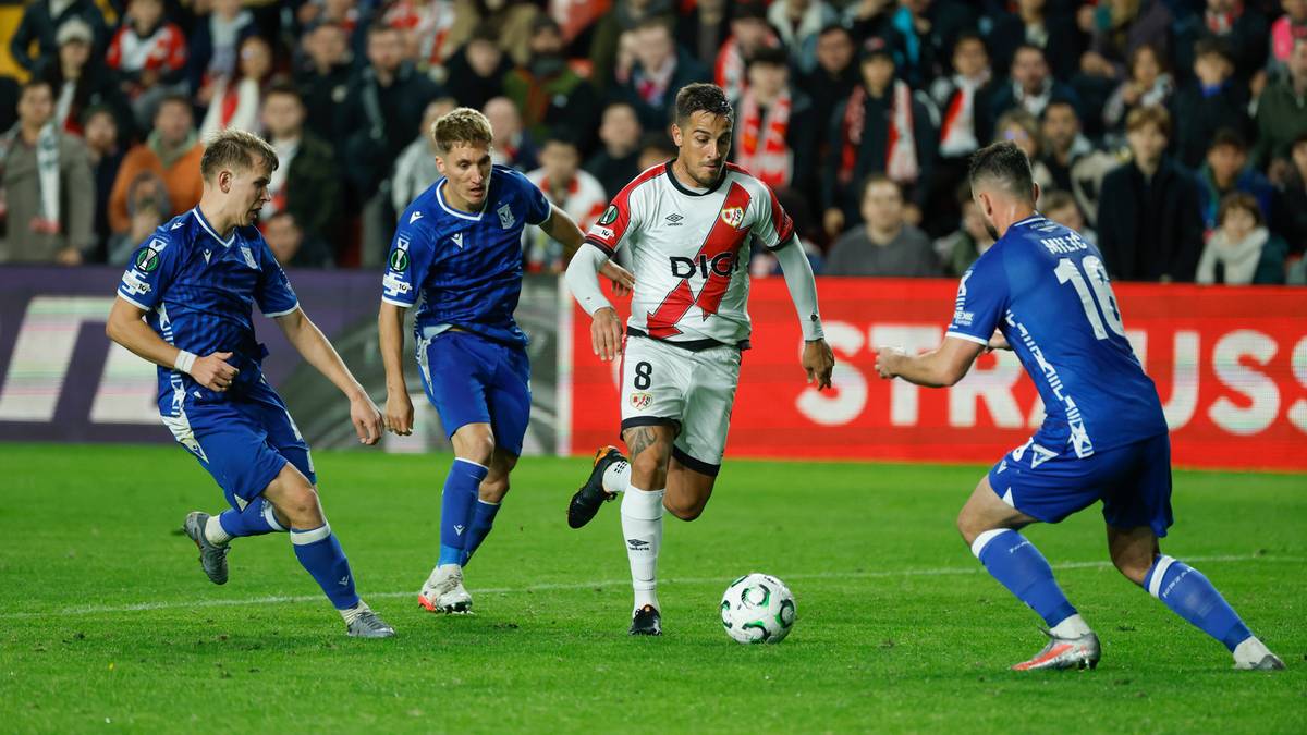 Piłkarze rywalizują o piłkę na boisku podczas meczu piłki nożnej.