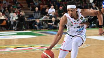 Dw&oacute;ch koszykarzy podczas meczu, jeden prowadzi piłkę, drugi go kryje.