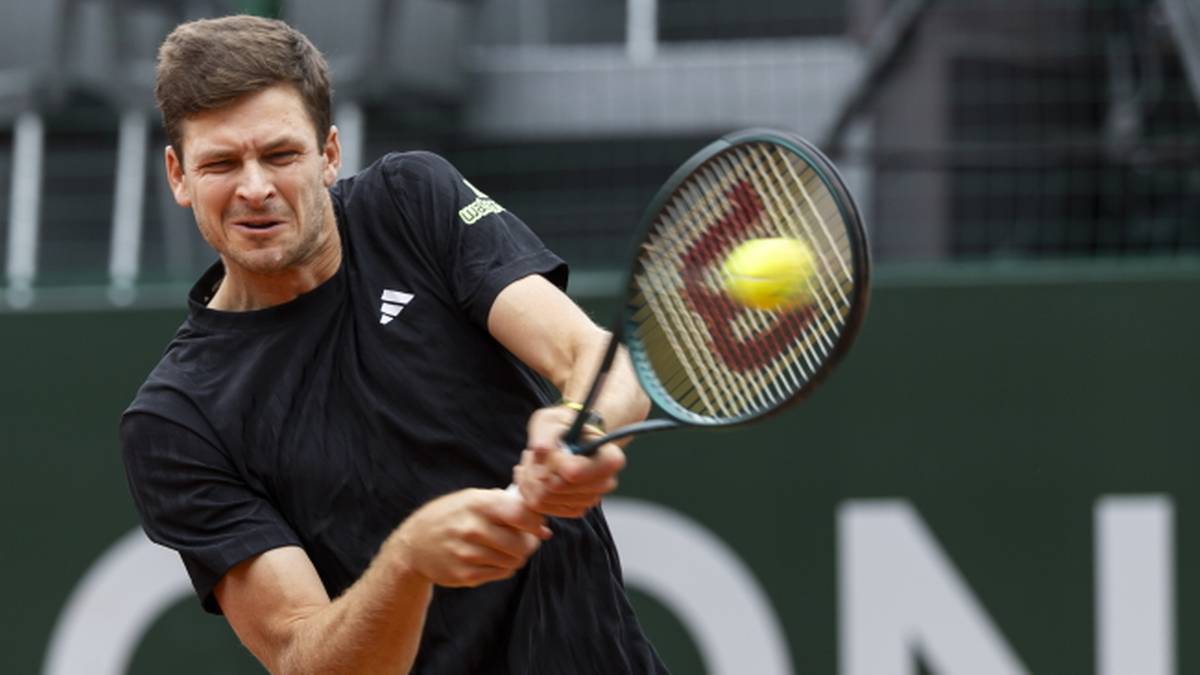 Hubert Hurkacz podczas meczu tenisowego, uderzający piłkę rakietą.