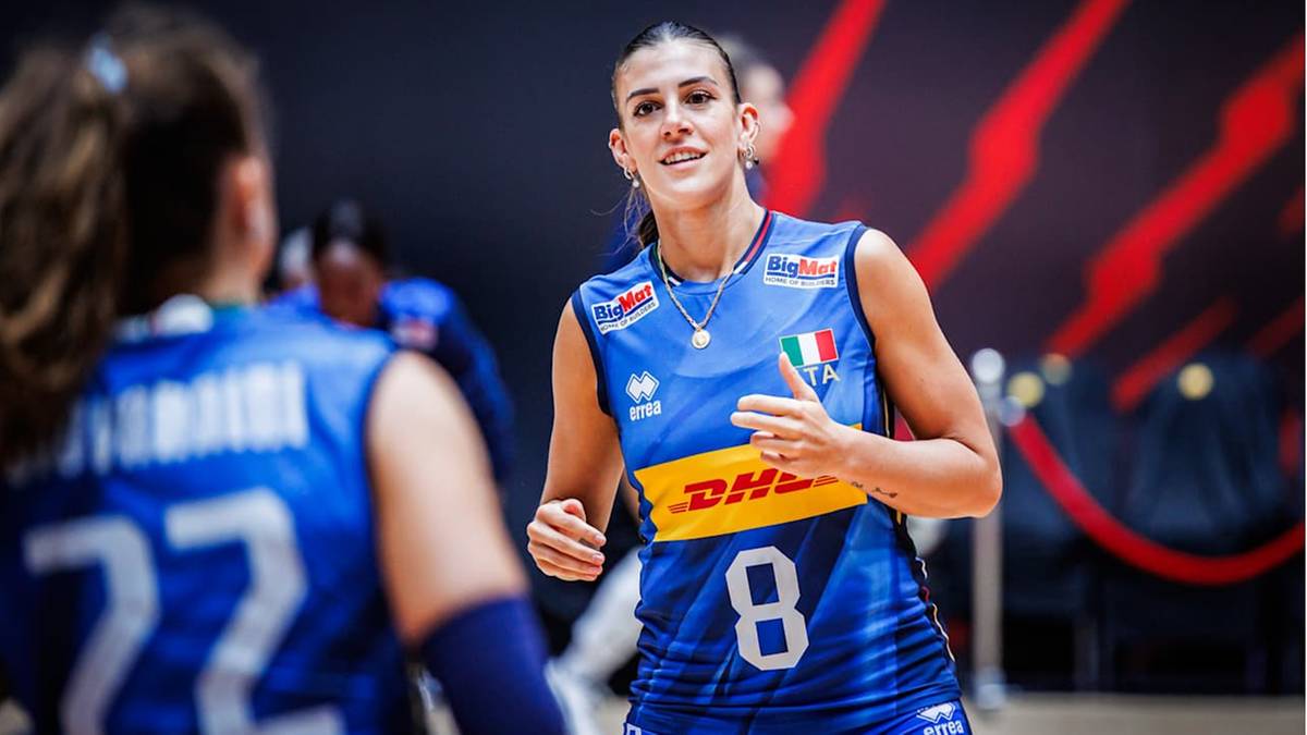 Siatkarka w niebieskiej koszulce z numerem 8, uśmiecha się.