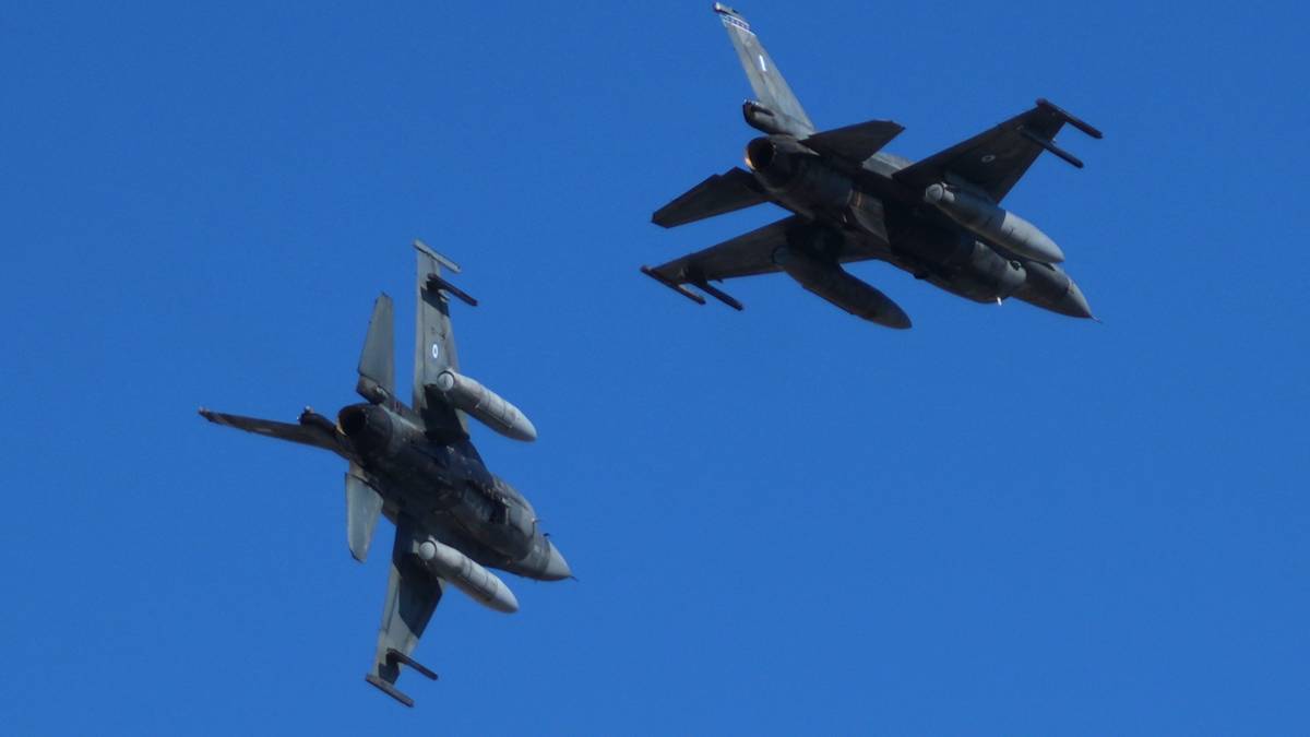 Dwa myśliwce F-16 lecące na tle błękitnego nieba.