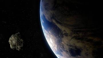 Widok z kosmosu na planetę Ziemia i zbliżającą się do niej asteroidę.