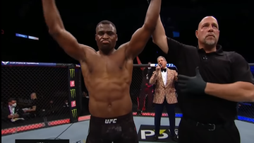 Francis Ngannou z uniesionymi rękami, stojący obok sędziego.