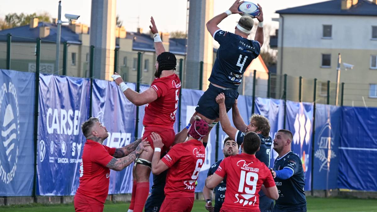 Gracze drużyny rugby walczą o piłkę w powietrzu podczas wrzutki z autu.