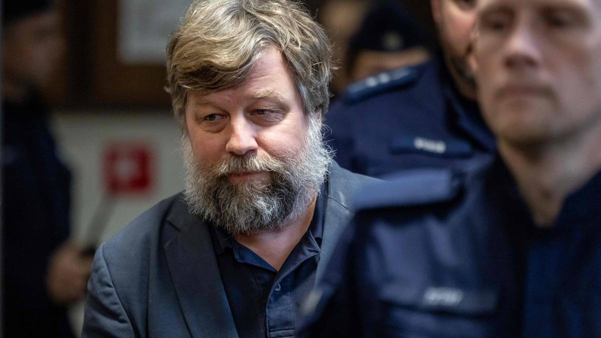 Aleksander Butiagin, rosyjski archeolog, z brodą, w ciemnej marynarce, otoczony przez osoby w mundurach.