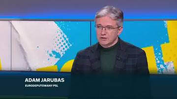 Adam Jarubas, eurodeputowany PSL, w okularach i marynarce, m&oacute;wi do kamery na tle kolorowego studia.