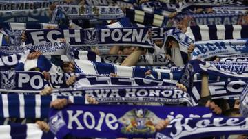 Tłum kibiców Lecha Poznań trzymających niebiesko-białe szaliki z napisami klubowymi.