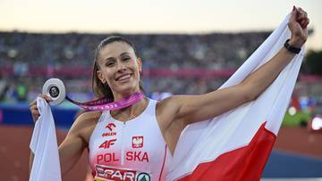 Uśmiechnięta polska lekkoatletka prezentuje medal i biało-czerwoną flagę Polski na tle stadionu.