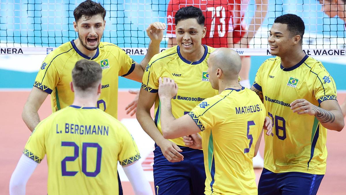 Grupa siatkarzy w żółtych koszulkach z numerami na plecach świętuje po udanej akcji.