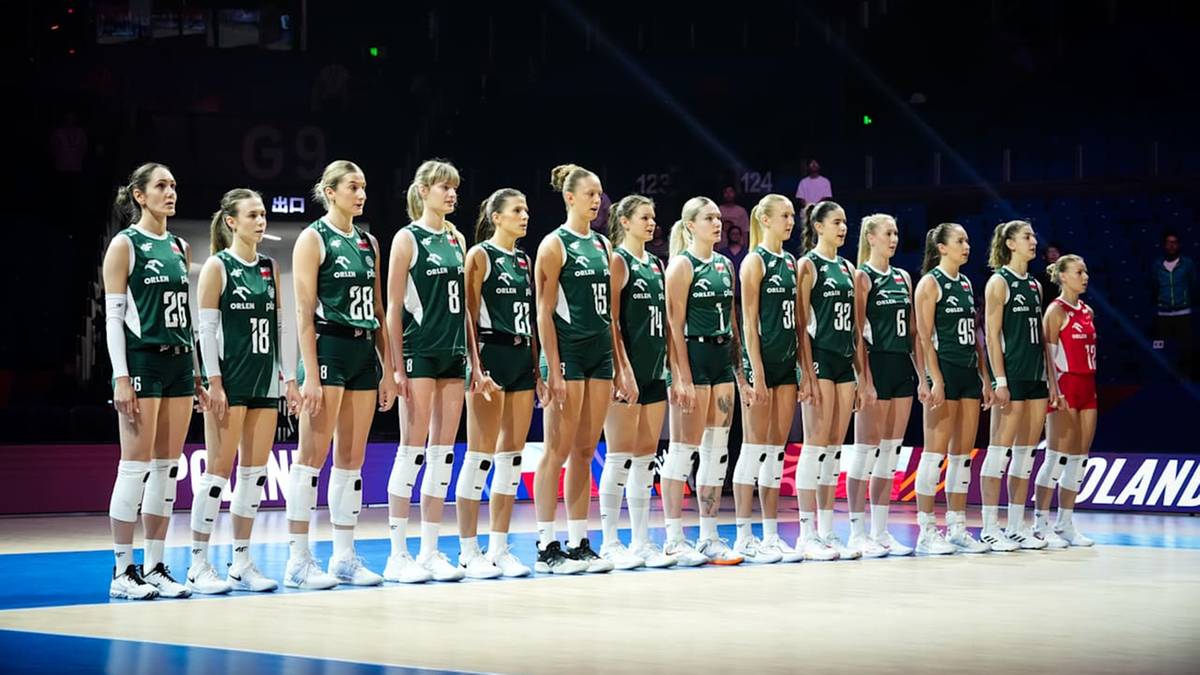 Drużyna polskich siatkarek w zielono-białych strojach sportowych ustawiona w rzędzie na boisku.
