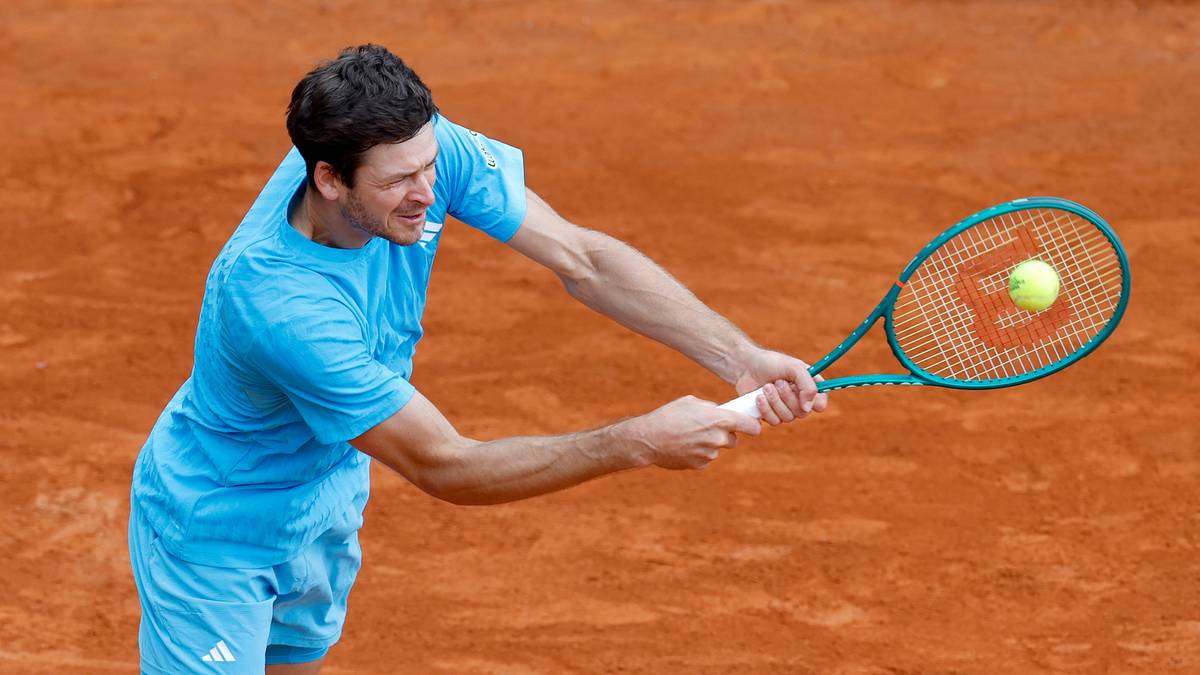 Tenisista Hubert Hurkacz wykonuje uderzenie na ceglanym korcie