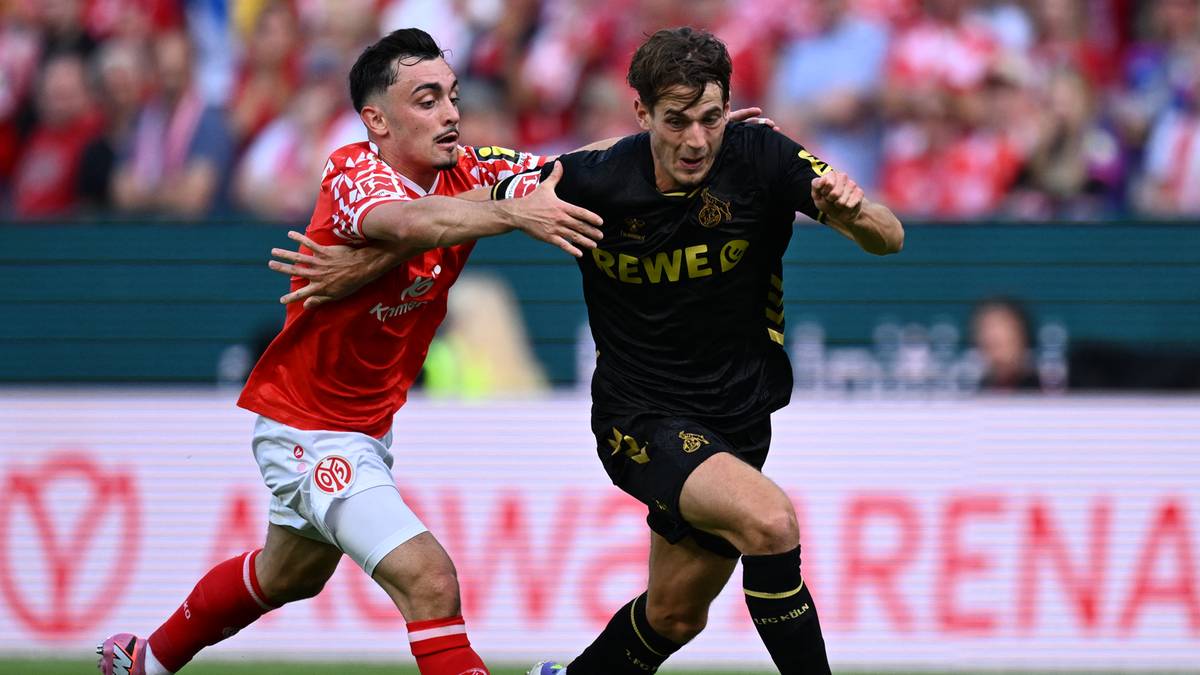 Dwóch piłkarzy walczy o piłkę na boisku piłkarskim podczas meczu.