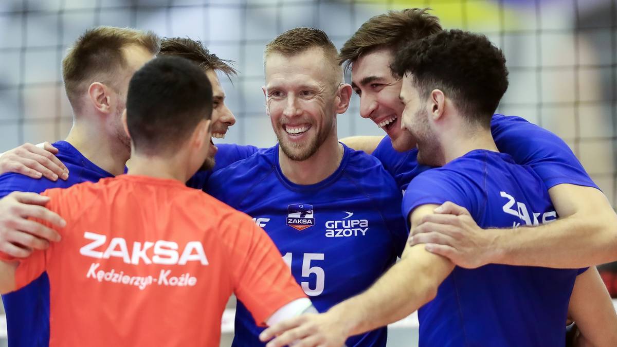 Grupa siatkarzy świętujących razem na boisku, jeden z nich ma na koszulce napis ZAKSA Kędzierzyn-Koźle.