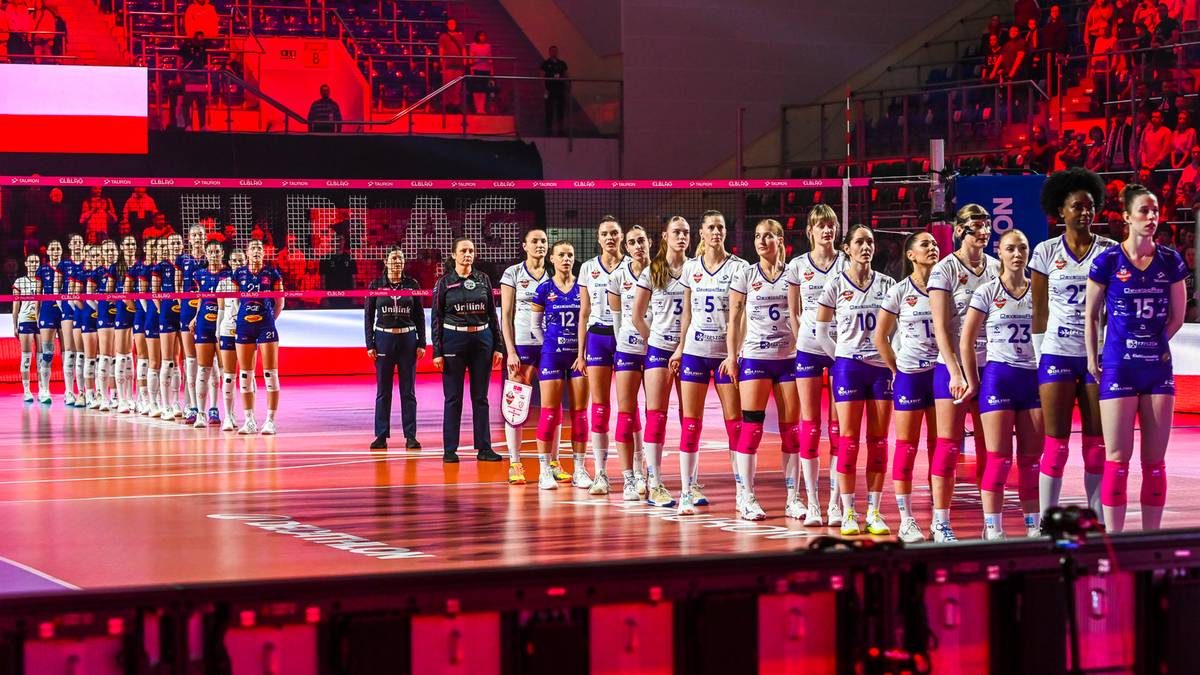 Drużyna siatkarek PGE Budowlanych Ł&oacute;dź stoi na boisku w hali sportowej przed rozpoczęciem meczu.