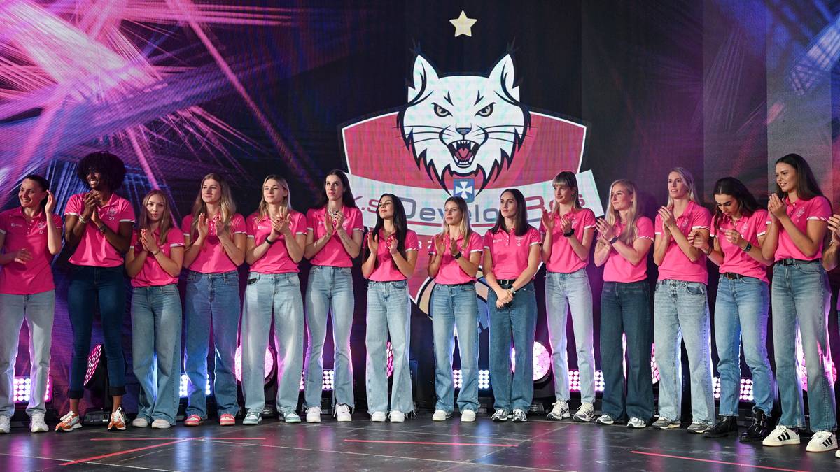 Drużyna siatkarska DevelopRes Rzeszów w kompletnym stroju na scenie z logotypem klubu.